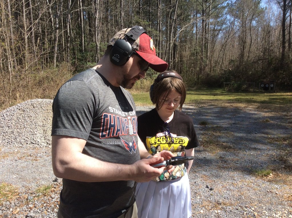 Dad teaching daughter the facts of a 22 revolver....Chad and Macie.jpg